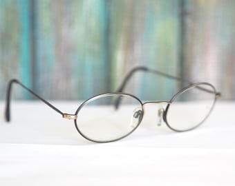 May include: A pair of black oval-shaped spectacles with thin metal frames.