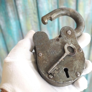 Peut inclure: Un cadenas vintage avec une clé, le cadenas est en métal et a une finition argentée. Le cadenas porte l'inscription "75 MM" et "CHROME".