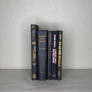 May include: A collection of six hardcover books with dark covers. The titles and authors are visible, including "Hanging by a Thread" and "An Ad for Murder." The spines are in varying shades of black and gray, with gold lettering.