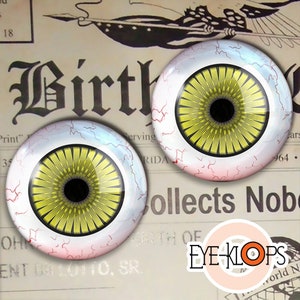 Pode incluir: Dois olhos de adereço grandes, de aparência realista, com íris amarelas, pupilas pretas e escleras brancas. Os olhos têm uma textura rachada e veiosa e são colocados sobre um fundo de jornal antigo.