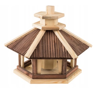May include: A wooden bird feeder with a hexagonal base and a shingled roof. The feeder has a brown stain and a natural wood finish.