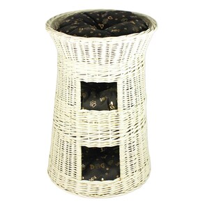 May include: White wicker cat tower with three cushioned beds. The beds have black fabric with gold paw prints.
