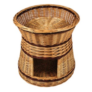 Può includere: Cuccia per animali domestici in vimini con un design bicolore. Il letto ha una parte superiore rotonda e un'area inferiore chiusa con un'apertura. La struttura intrecciata presenta toni naturali e marrone scuro.