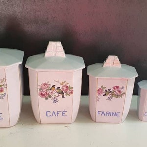 Puede incluir: Conjunto de cinco botes de cerámica blanca con diseños florales y de pájaros. Los botes están etiquetados con "SUCRE", "CAFÉ", "FARINE", "EPICES" y "VIN".