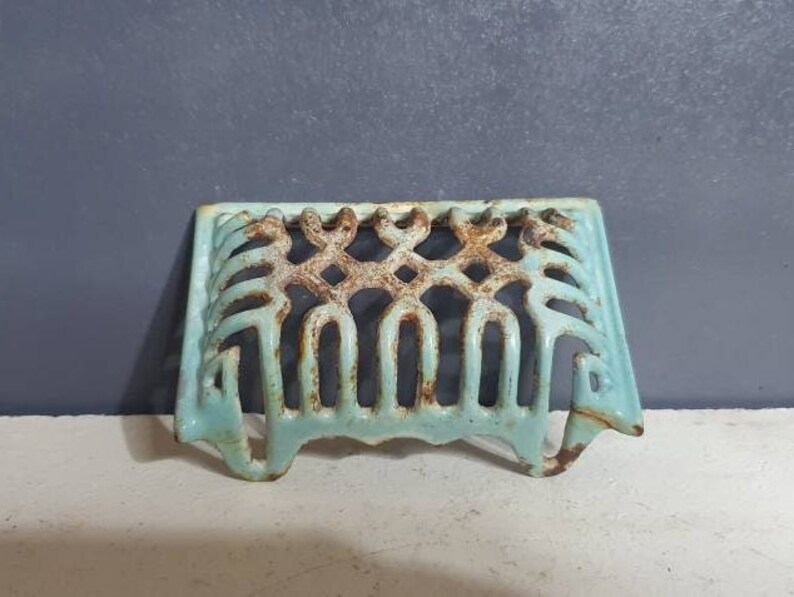 Pu&ograve; includere: Una griglia in ghisa blu chiaro con un design decorativo. La griglia &egrave; progettata per adattarsi all'apertura di un camino.