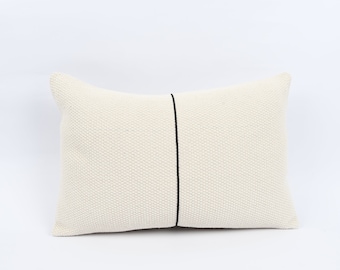 May include: A white rectangular cushion with a black line down the centre.