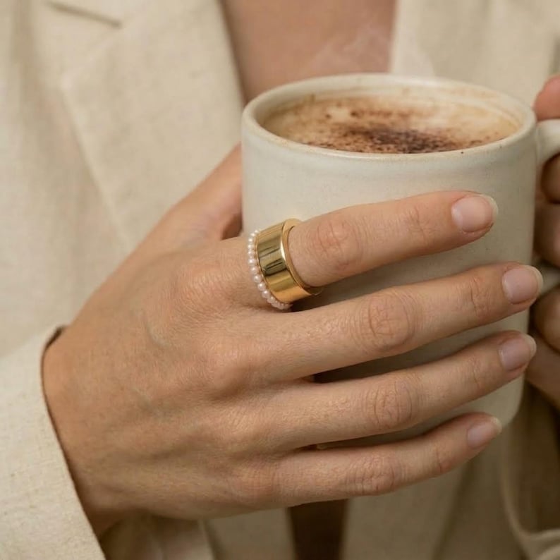 May include: A set of three ceramic mugs with a speckled, matte finish. Each mug features a different color: light blue, cream, and gray. The mugs have a simple, modern design, perfect for coffee or tea.
