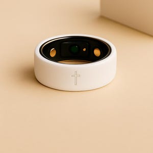 May include: A white smart ring with a black interior and gold accents. The ring features a cross symbol on the exterior and is designed for health tracking. The ring's dimensions are not visible in the image.