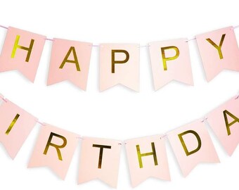 May include: Pink and gold Happy Birthday banner with gold foil letters. The banner is strung together with white string.