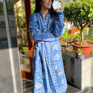 May include: A blue and white floral print robe with a white trim. The robe is tied at the waist with a matching sash.