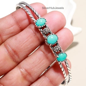 May include: Silver bangle bracelet with a twisted design and four turquoise stones set in silver with floral accents.  SilverHubJewels.