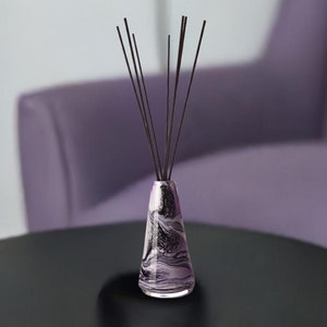 May include: A black and white marbled glass diffuser bottle with black diffuser sticks.