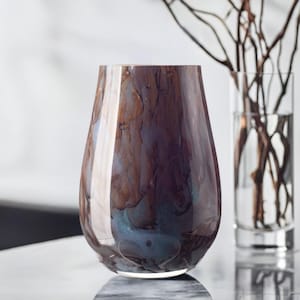 May include: A brown and blue glass vase with a marbled design. The vase is round and has a wide opening.