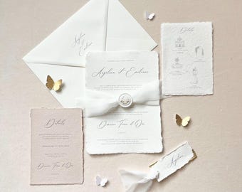 Può includere: Elegante suite di inviti di nozze con busta bianca, biglietti d'invito e biglietti di dettaglio. La suite include un nastro, un sigillo di cera e dettagli di farfalle dorate e bianche. Il testo "Angelina et Emiliane" è visibile.