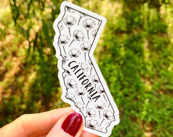 May include: White sticker with a black outline of the state of California. The state is filled with a pattern of black and white flowers. The word "CALIFORNIA" is written vertically along the right side of the state.