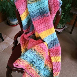 Hand made blanket in shades of pink, blue, yellow, orange ,green.  It has a colorful and bright beachy vibe that measures 40x65 inches