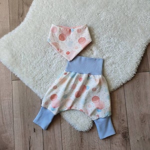 Könnte beinhalten: Ein Set Babykleidung mit einem weißen und blauen Muster aus Aquarellkreisen. Das Set beinhaltet eine blaue und weiße Hose und eine passende Lätzchen.