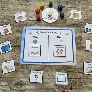 May include: A visual schedule board with the words "My Now & Next Board" printed at the top. The board is divided into two sections, "Now" and "Next". Each section has a variety of picture cards with activities such as "Breakfast", "Brush teeth", "Get dressed", and "Watch TV".
