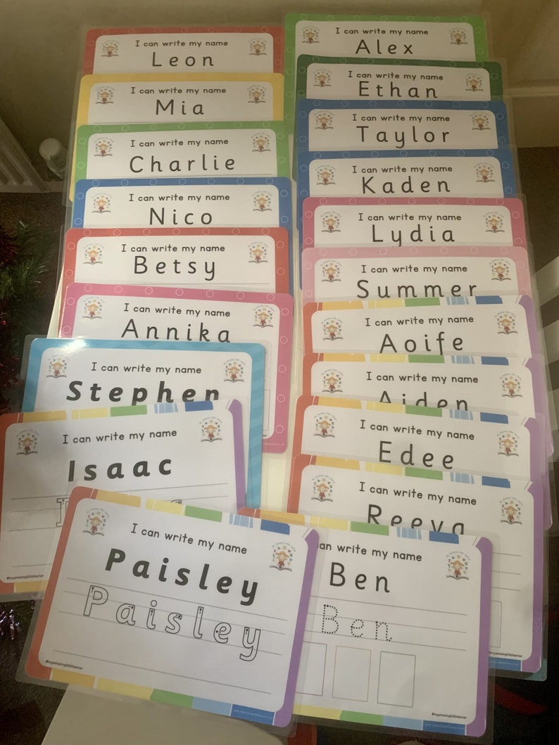 Pode incluir: Um conjunto de cart&otilde;es coloridos com a frase "Eu posso escrever meu nome" e um espa&ccedil;o para escrever um nome. Os nomes incluem Leon, Mia, Charlie, Nico, Betsy, Annika, Stephen, Isaac, Paisley, Alex, Ethan, Taylor, Kaden, Lydia, Summer, Aoife, Aiden, Edee, Reeva e Ben.