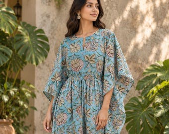 May include: A light blue kaftan dress featuring a repeating floral pattern in shades of pink, green, and brown. The garment has a round neckline with a small slit, wide kimono-style sleeves, and a drawstring waist that creates a gathered effect.