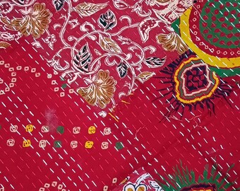 May include: A patchwork quilt featuring a vibrant red base with intricate floral and geometric patterns in yellow, green, white, and brown. The fabric is held together by visible white running stitches that create a textured kantha embroidery effect.
