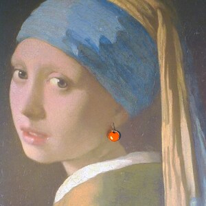 May include: A painting of a woman wearing a blue and gold headscarf with a single orange pearl earring. The woman is looking to the left of the viewer.