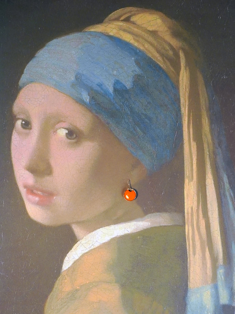 May include: A painting of a woman wearing a blue and gold headscarf with a single orange pearl earring. The woman is looking to the left of the viewer.