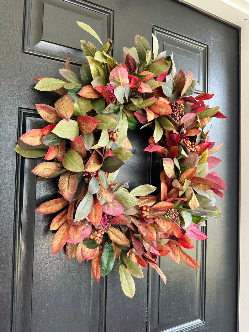 Pode incluir: Uma coroa de outono com folhas de cor bord&ocirc;, verde e dourado e bagas vermelhas. A coroa &eacute; feita de folhagem artificial e &eacute; perfeita para decorar uma porta de entrada.