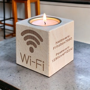 Könnte beinhalten: Ein Holz-Kerzenhalter mit einem Wi-Fi-Symbol und dem Text "Wi-Fi" auf der Vorderseite. Der Halter hat auch den Text "Netzwerk: Fritzbox7590" und "Passwort: 123ilovePIZZA!" auf der Seite eingraviert.