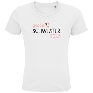 personalisiertes weißes t-shirt mit dem text große schwester 2025, mit boho herz Motiv. t-shirt zur schwangerschaft verkünden.