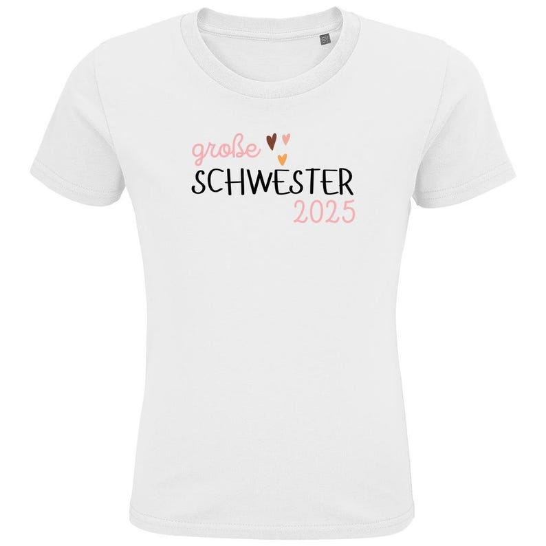 personalisiertes weißes t-shirt mit dem text große schwester 2025, mit boho herz Motiv. t-shirt zur schwangerschaft verkünden.