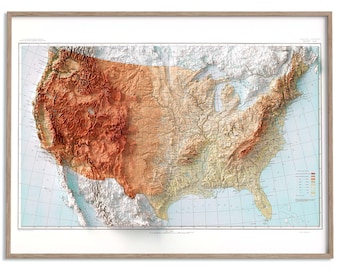 Pode incluir: Um mapa em relevo 3D emoldurado dos Estados Unidos, mostrando a topografia do país. O mapa apresenta um gradiente de cores do marrom ao bege, com um fundo azul claro. É emoldurado em uma moldura de madeira marrom claro.