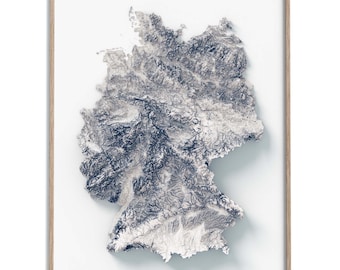 May include: A 3D topographical map of Germany, printed in shades of blue and white on a white background. The map is framed in a light wood frame.