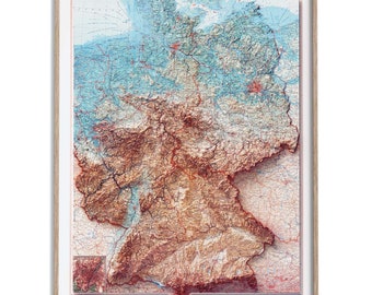 Könnte beinhalten: Eine gerahmte 3D-Reliefkarte von Deutschland mit einer detaillierten topografischen Darstellung der Landschaft des Landes. Die Karte zeigt einen Farbverlauf von Blau zu Braun, der die Höhenunterschiede anzeigt. Die Karte ist von einem hellen Holzrahmen umgeben.