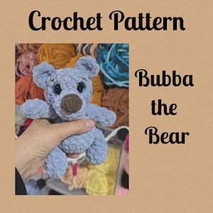Puede incluir: Un oso de ganchillo azul claro llamado "Bubba the Bear" con una nariz marrón y ojos azules grandes. La imagen incluye el texto "Crochet Pattern" en la parte superior. El oso se sostiene en una mano, con hilo colorido en el fondo.