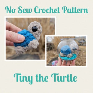 Peut inclure: Modèle de crochet sans couture : Tiny la tortue. Un jouet en crochet amigurumi en forme de tortue, bleu et gris, avec des yeux noirs, est présenté dans une main et dans un bocal en verre.