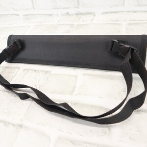 May include: Black canvas carrying case with adjustable shoulder strap and two buckle closures.