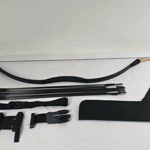 May include: A black bow and arrow set with a wooden handle. The set includes a bow, arrows, a quiver, and other accessories. The bow is curved and has a black string. The arrows are black with silver tips.