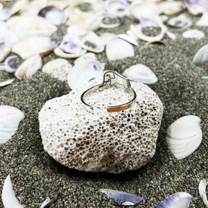 Puede incluir: Anillo de plata con dise&ntilde;o de elefante. El anillo est&aacute; sobre una roca blanca con textura rugosa.