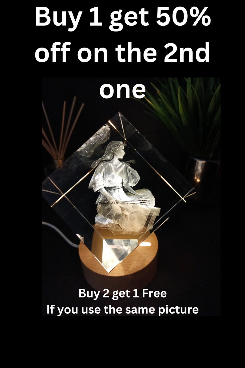 Puede incluir: Una escultura de cristal transparente en forma de diamante de una mujer tocando un instrumento de cuerda, iluminada desde abajo por una luz c&aacute;lida. La escultura se encuentra sobre una base de madera. El texto de la imagen dice "Buy 1 get 50% off on the 2nd one" y "Buy 2 get 1 Free If you use the same picture."