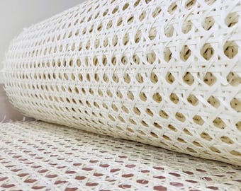 Könnte beinhalten: Eine Rolle cremefarbenes gewebtes Rohrgeflecht. Das Geflecht ist eng gewebt mit einem sich wiederholenden Muster aus kleinen, gleichmäßig verteilten Löchern. Das Material ist aufgerollt, mit einem Teil abgerollt, das die Textur zeigt.