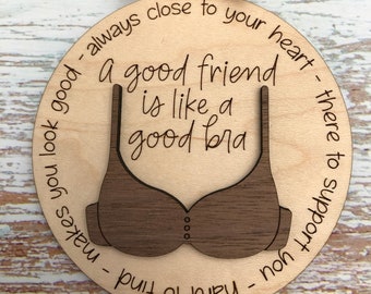 May include: A wooden ornament with a brown bra cutout and the text "A good friend is like a good bra - always close to your heart - there to support you - hard to find - makes you look good".