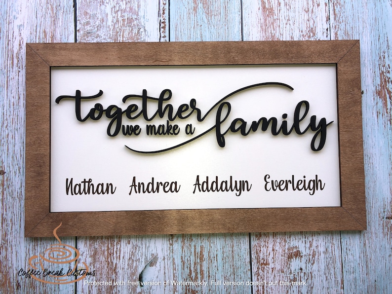 Op de afbeelding: Een houten ingelijst bord met de tekst "Together we make a family" in zwarte cursieve letters. De namen Nathan, Andrea, Addalyn en Everleigh staan onder de tekst.
