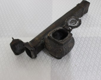 Op de afbeelding: Een vintage inktpot van messing met een scharnierend deksel en ingewikkelde houtsnijwerk. De inktpot bestaat uit twee delen, een lange rechthoekige basis en een ronde container met een deksel.