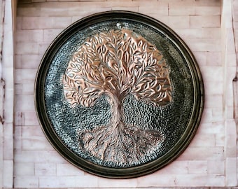 May include: A round metal wall decor with a copper-colored tree of life design. The tree has intricate branches and roots, and the background is a dark green color.