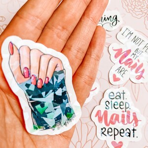 May include: A set of five stickers featuring nail art designs and phrases related to nail care. The stickers include a hand with manicured nails, a heart with the text "I'm not perfect but my nails are", a heart with the text "eat sleep nails repeat", and a heart with the text "naily".