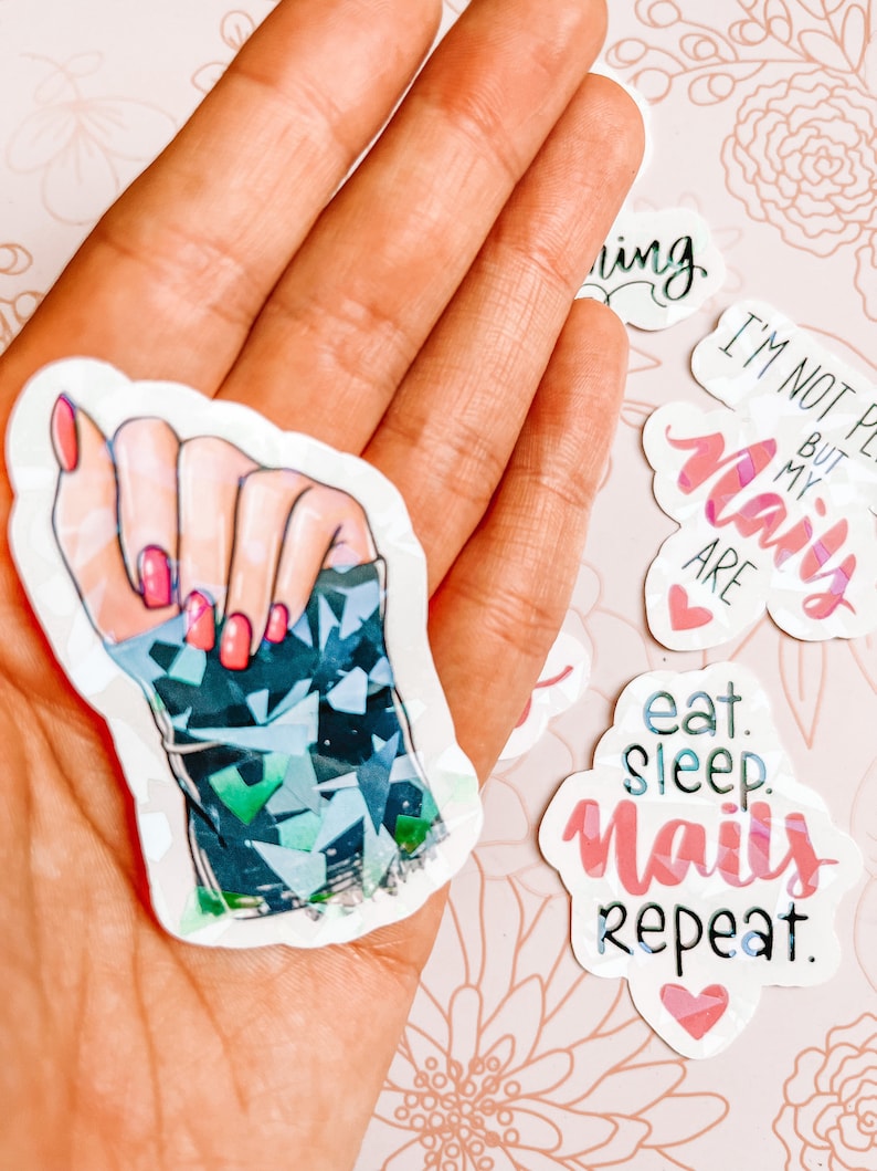 May include: A set of five stickers featuring nail art designs and phrases related to nail care. The stickers include a hand with manicured nails, a heart with the text "I'm not perfect but my nails are", a heart with the text "eat sleep nails repeat", and a heart with the text "naily".