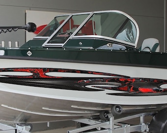 Könnte beinhalten: Ein grünes und weißes Aluminium-Fischerboot mit einem schwarzen und roten Grafikdesign an der Seite. Das Boot steht auf einem Anhänger mit einem Mercury-Außenbordmotor.