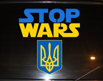 Pode incluir: Um vidro de carro com um adesivo azul e amarelo que diz "STOP WARS" com o símbolo do tridente ucraniano abaixo.