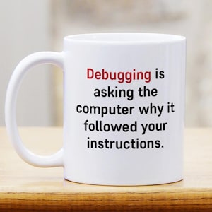 May include: A white ceramic mug featuring the black text "Debugging is asking the computer why it followed your instructions." The word "Debugging" is printed in red, while the rest of the sentence is in black, centered on the mug.